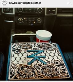 a coffee cup sitting on top of a table in front of a car dash board