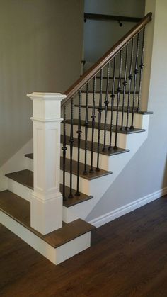 a stair case in a house with wood floors and white railings on the stairs