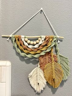 there is a wall hanging made out of woven material and wood beads on the string