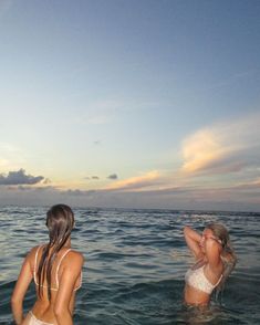 two women in the water at sunset