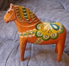 a wooden toy horse sitting on top of a bed