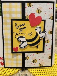 a close up of a card with a bee on it and some hearts in the background