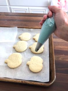 a person is spreading icing on some cookies