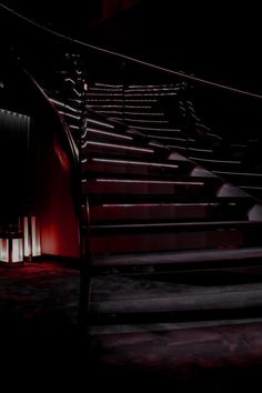 the stairs are lit up at night with red lights on them and there is no one in the photo