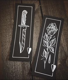 two black and white bookmarks with roses on them, one has a knife in it