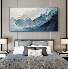 a large painting hanging above a bed in a room with two lamps on either side of the bed