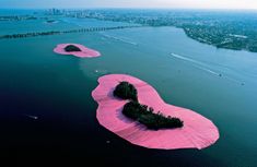 an island covered in pink paper floating on top of water