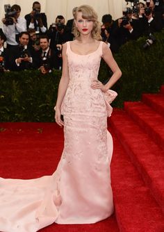 taylor swift at the 2013 met ball wearing a pink gown and red lipstick with her hands on her hips