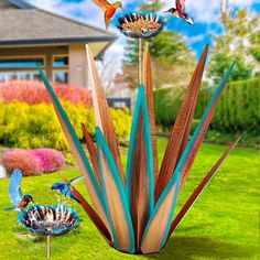 two birds are sitting on top of a bird bath in the grass next to some flowers