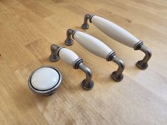 four white handles and knobs on a wooden table