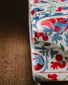 a close up view of a flowered fabric on the floor with a brown background