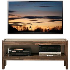 a flat screen tv sitting on top of a wooden shelf