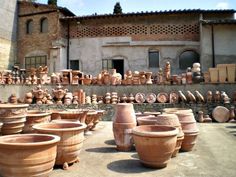 many clay pots are lined up in front of an old building