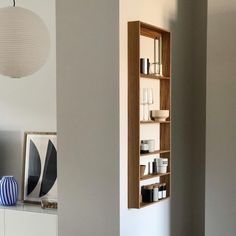 an empty shelf in the corner of a room with vases and other items on it