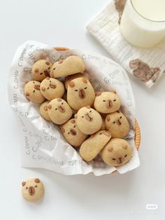 some cookies are in a paper bag on a table next to a glass of milk