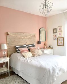 a bedroom with pink walls and white furniture