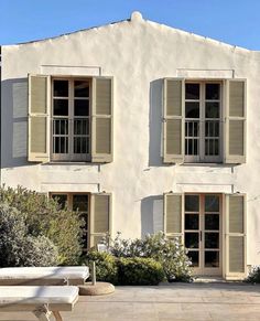 a white house with three windows and shutters