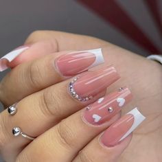 a woman's hand with some pink and white nail polishes on her nails