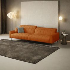 an orange couch sitting on top of a rug in a living room next to a window