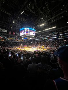 a basketball game is being played in an arena with people watching from the sidelines