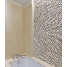 a bath tub sitting under a window next to a tiled wall in a room with beige walls