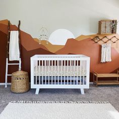 a baby's room with a mountain mural and white crib in the foreground