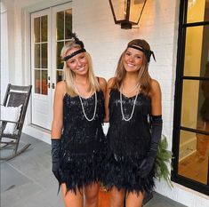 two young women dressed in flap style garb standing next to each other on a porch