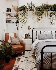 a bed room with a neatly made bed and lots of plants