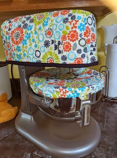 a multicolored floral seat cushion sits on an ironing board