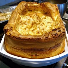 a cake sitting on top of a white plate next to pans of other food