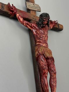 a wooden crucifix with a man on the cross painted red and gold