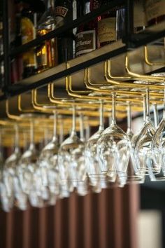 several wine glasses are lined up on a rack