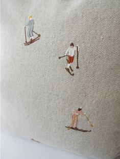 an embroidered pillow with skiers on it