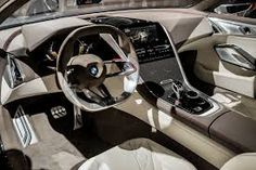 the interior of a modern car with leather and wood trims, including an automatic steering wheel