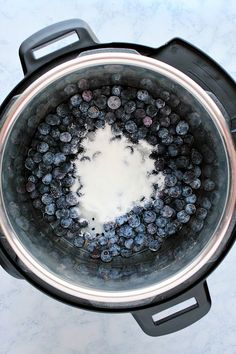 blueberries are in the bottom of an electric pressure cooker, with water inside