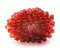 a red flower shaped glass object on a white surface