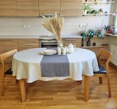 a table with two cups and plates on it in the middle of a wooden floored kitchen