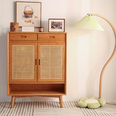 a wooden cabinet sitting on top of a rug next to a lamp