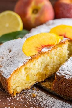 a close up of a piece of cake with fruit on the side and powdered sugar