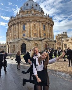 two young women standing in front of an old building