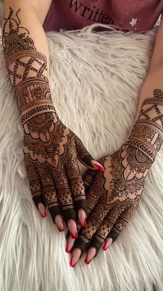 a woman's hands with henna tattoos on them