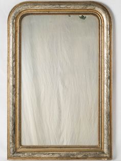 an ornate gold framed mirror against a white wall with no one in it's frame