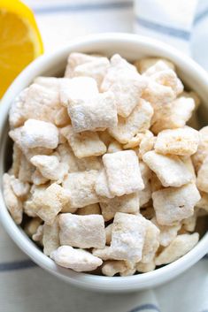 a bowl filled with sugar cubes next to an orange slice