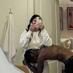 a woman taking a selfie in the mirror with her cell phone and headphones on