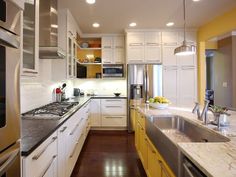 a kitchen with white cabinets and yellow counter tops, stainless steel appliances and an oven