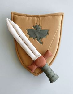 a brown and white object on top of a tan cloth with a green leaf design