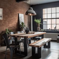 an industrial style dining room with brick walls and wooden tables, black chairs and potted plants