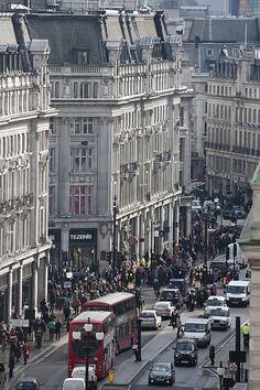 a busy city street filled with lots of traffic and tall buildings on both sides of the road