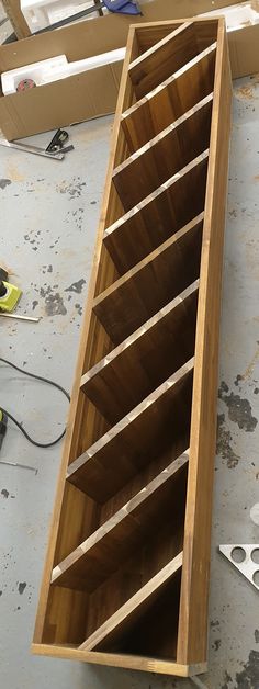 a large wooden shelf sitting on top of a floor next to scissors and pliers