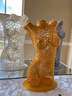 three vases sitting on top of a glass table next to each other in front of a window